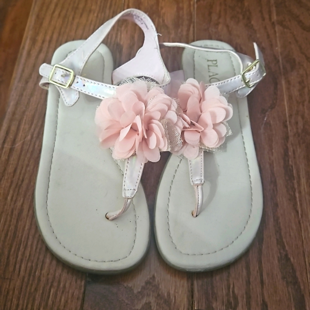 Children place pink size 1 sandals